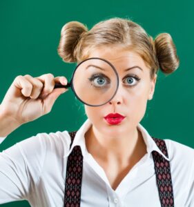 Femme qui regarde dans une loupe